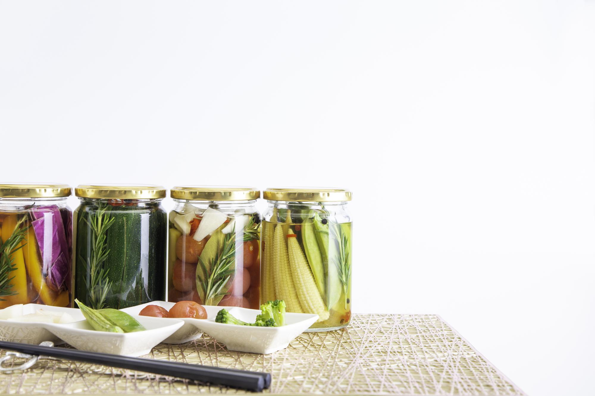Workshop table with jars of herbs and raw vegetables