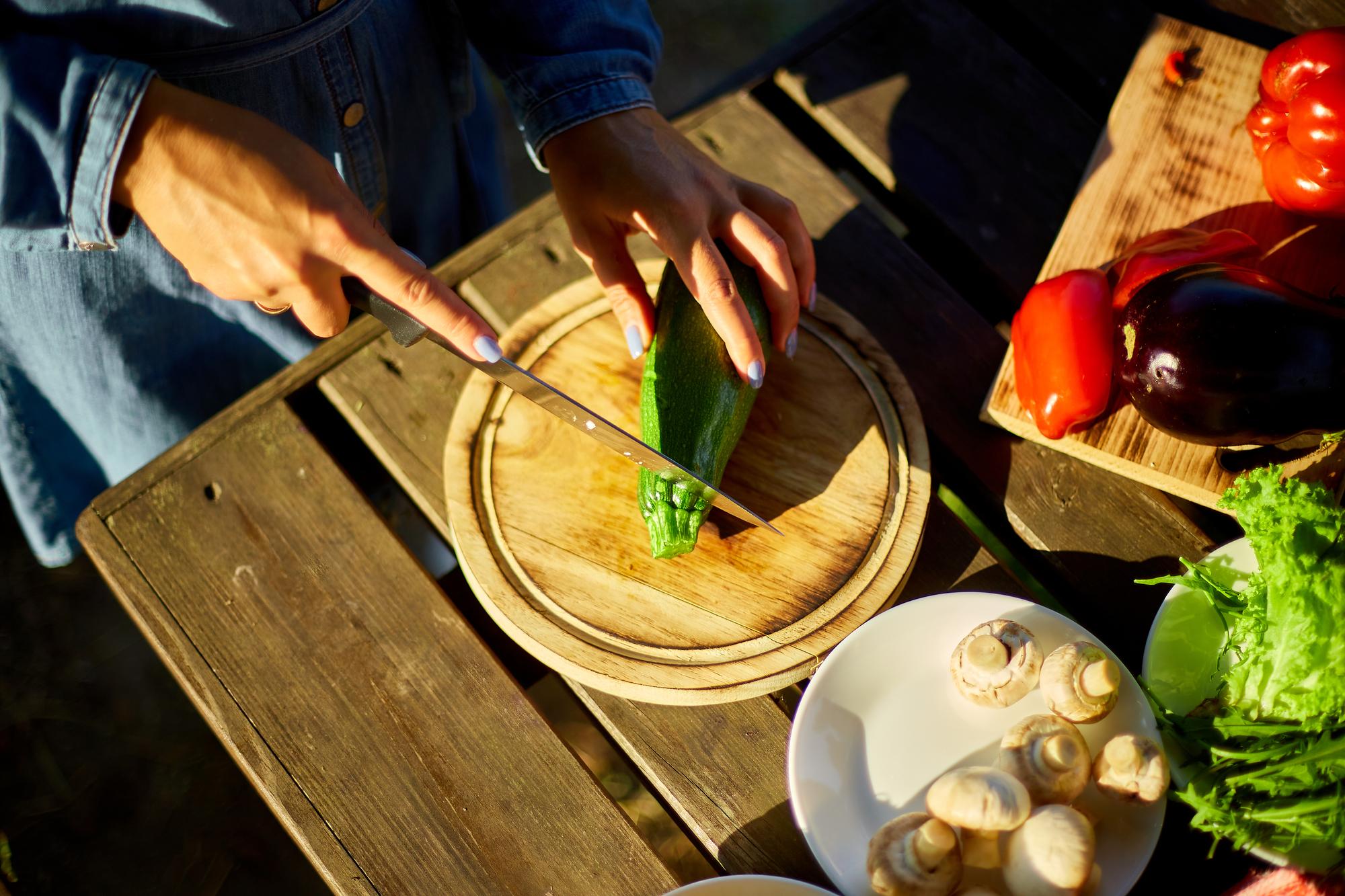 Chef plating seasonal dish on wooden table